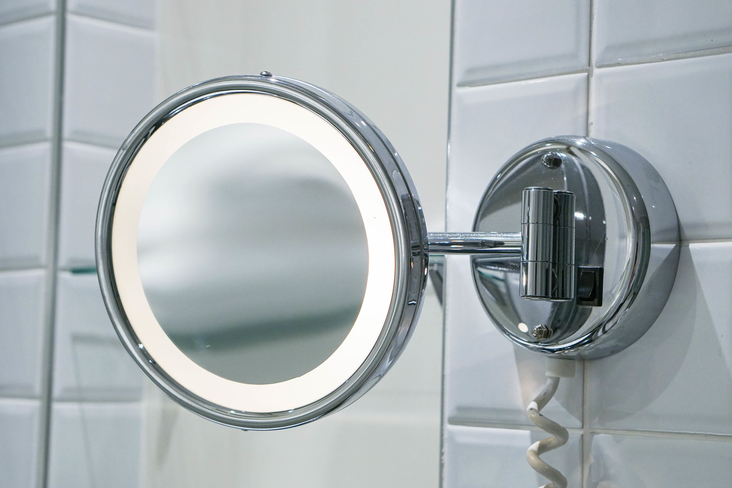 lighted magnifying mirror on wall
