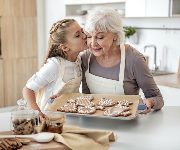 grandma in kitchen with granddaughter cookies